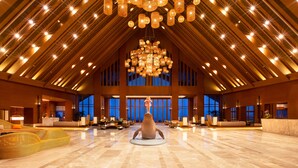 A spacious lobby with a high ceiling, large windows, and a central sculpture. - DoubleTree by Hilton Shanwei (Shanwei)