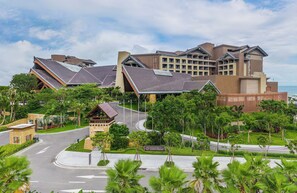 A hotel with multiple buildings, a landscaped area with palm trees, and a road leading to the entrance. - DoubleTree by Hilton Shanwei (Shanwei)