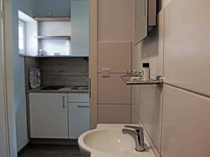 Une salle de bain moderne avec un lavabo blanc, un robinet chromé et un miroir au-dessus.