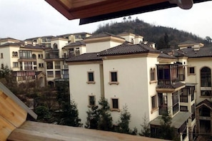 A multi-story residential building with a traditional architectural style, featuring balconies and large windows. - Taimei Holiday Hotel (Chongqing)