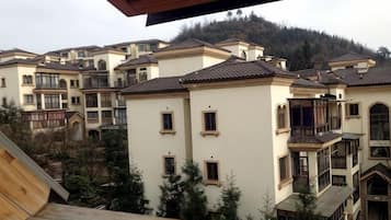 A residential area with multiple two-story buildings, balconies, and a hilly background.