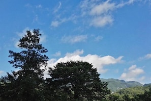 A clear sky with scattered clouds and a mountain range in the background. - Taimei Holiday Hotel (Chongqing)