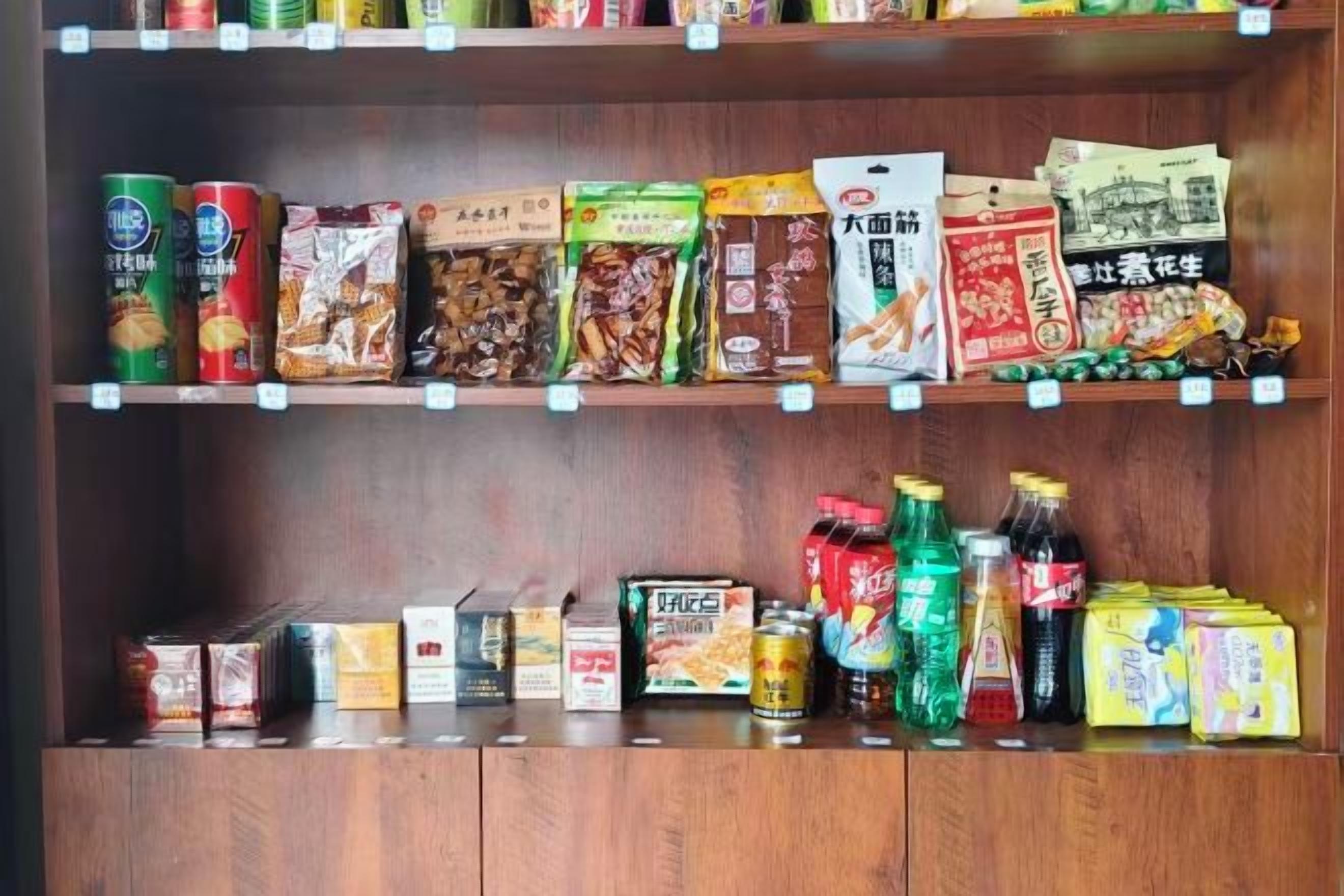 A shelf stocked with various packaged food items and beverages.