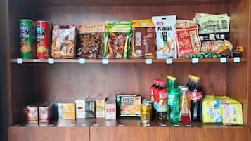A shelf stocked with various packaged food items and beverages.