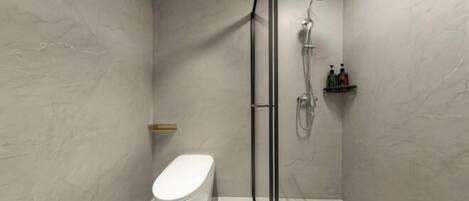 A modern bathroom with a toilet, shower, and a shelf with toiletries.