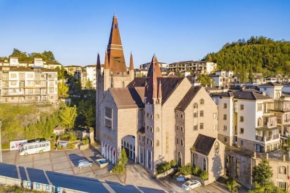 A historic building with a prominent tower and arched windows, surrounded by modern residential buildings. - Taimei Holiday Hotel (Chongqing)