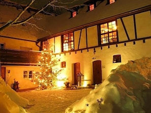 A building with a traditional facade, multiple windows, and a snow-covered ground.