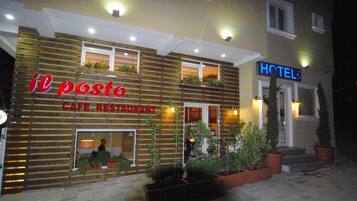 Un immeuble abritant un café-restaurant appelé « il posto » et portant une enseigne d’hôtel.