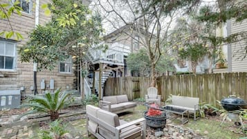 Relax in the patio area with a sofa, chair, and table, and enjoy the barbecue grill and fire pit.