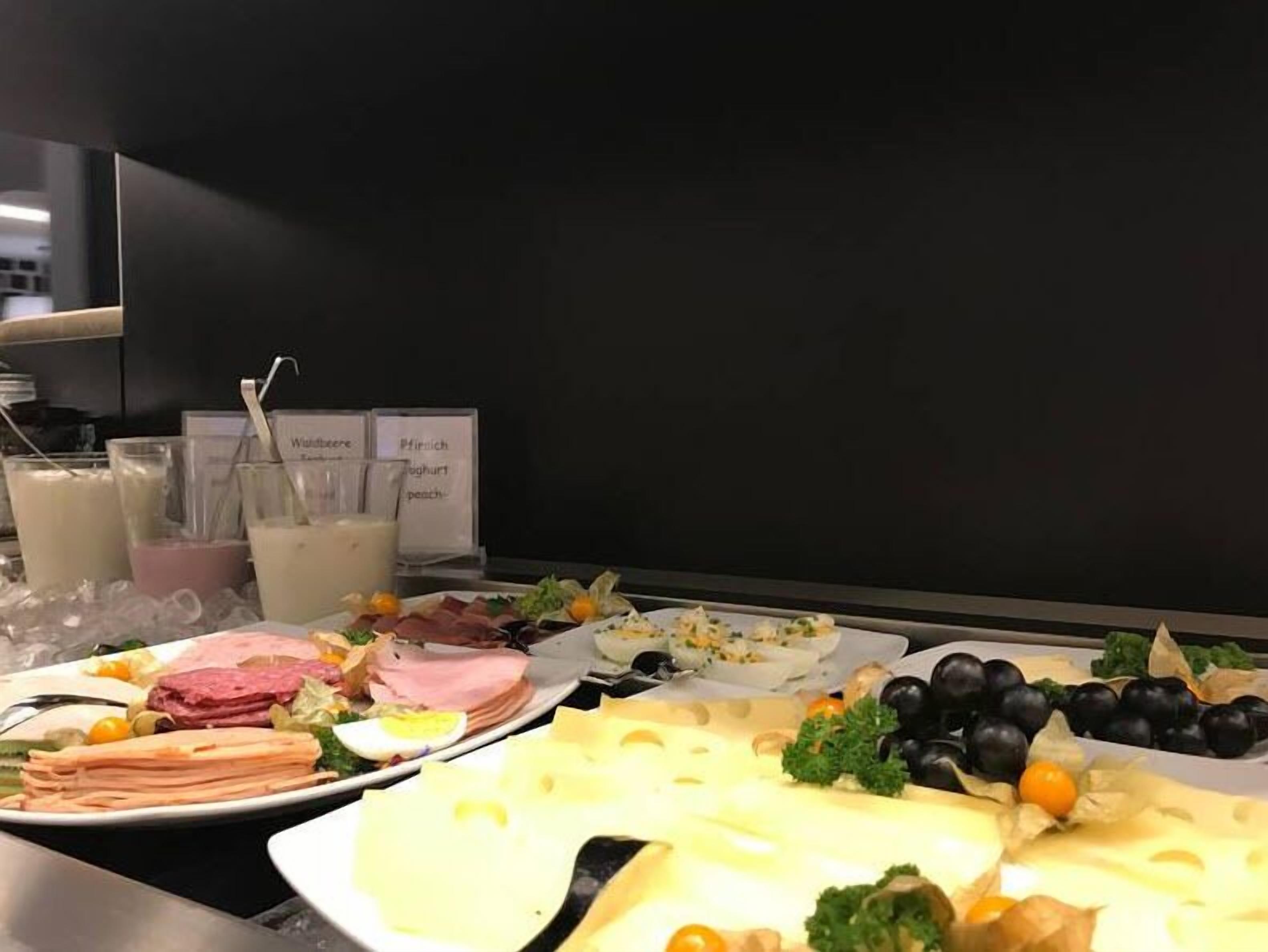 Noutopöytä, jossa on tarjolla monenlaista ruokaa, kuten lihaa, juustoja ja hedelmiä.