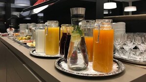 Uma mesa de buffet com diversas bebidas e pratos.