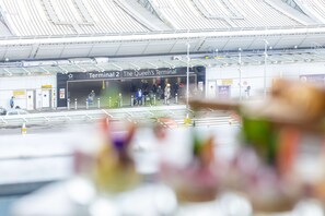 Terminal 2 at an airport, with a sign reading "The Queen's Terminal." - Hilton Garden Inn London Heathrow Terminal 2 and 3 (Hounslow)