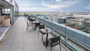 A rooftop terrace with seating and a view of the airport.