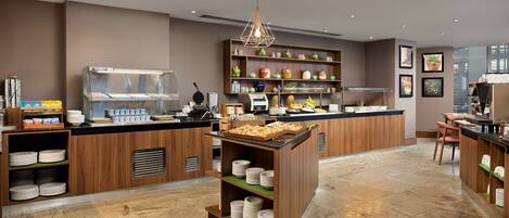 A modern kitchen with wooden cabinetry, a central island, and a variety of kitchen appliances.