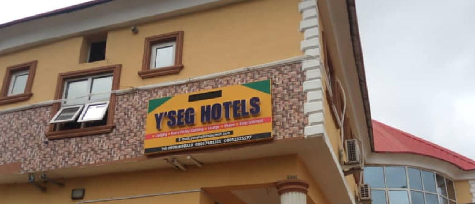 A hotel sign with the name 'Y'SEG HOTELS' and contact information.
