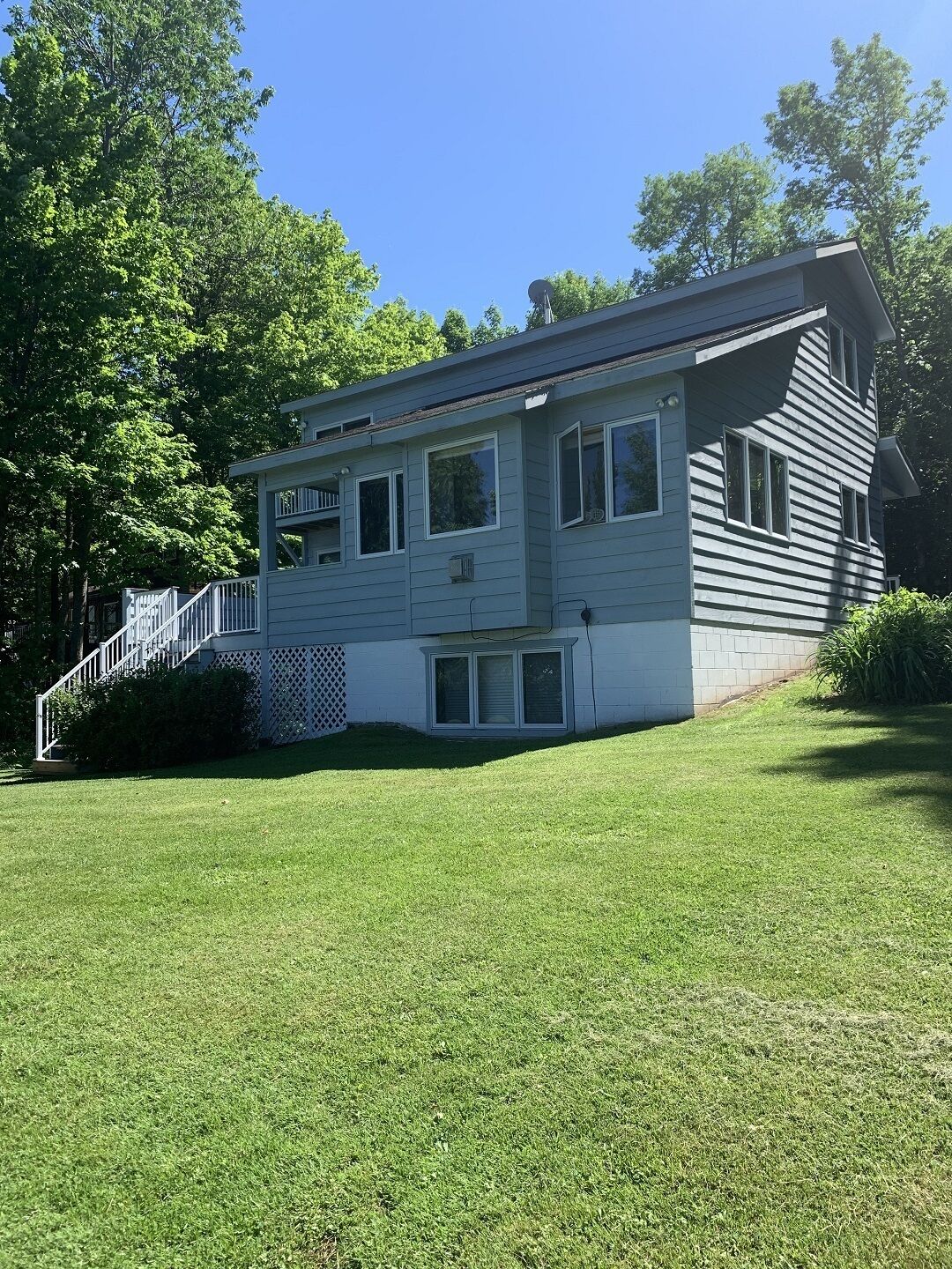 A two-story house with a front porch and a small deck.