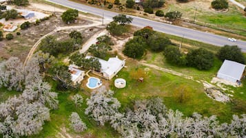 Surrounded by lush trees and open spaces, this property features a main house and a swimming pool.