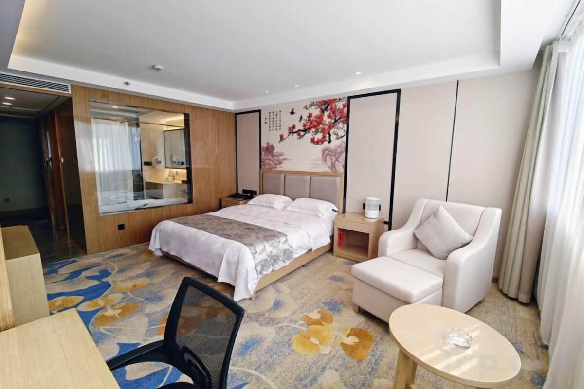 Una habitación de hotel con una cama, un escritorio, una silla, un sofá y una mesita.