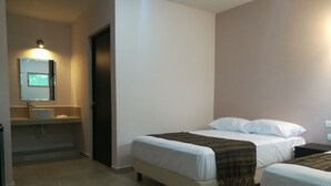 A hotel room with a bed, a bedside table, a mirror, and a bathroom with a sink and toilet. - Hotel Virreyes (Mérida)