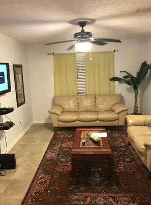 Quarto básico, várias camas, para não fumantes, vista para a praia | Sala de estar | Smart TV 40 polegadas com canais a cabo, TV