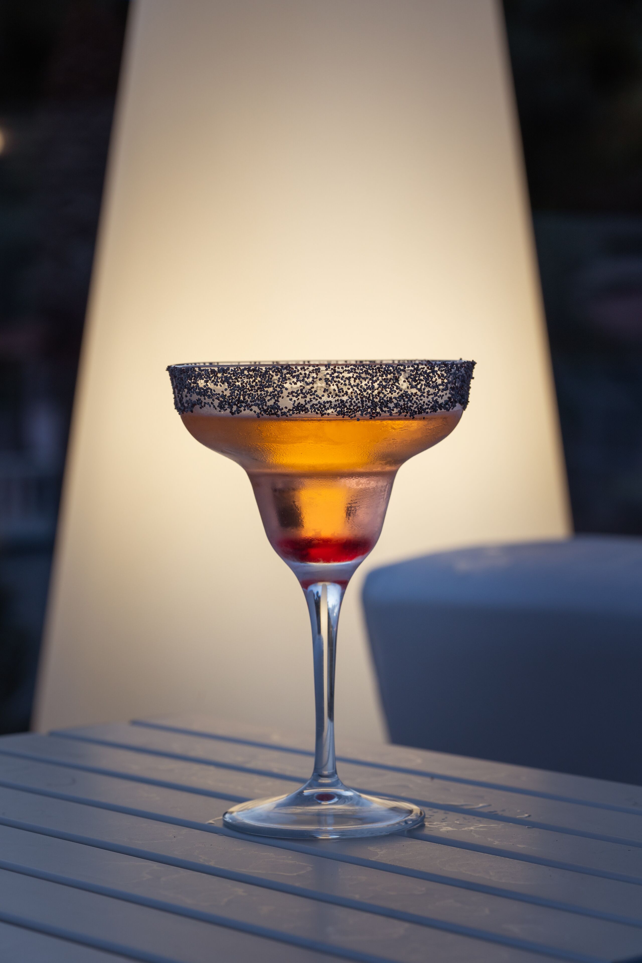 Een margarita glas op een metalen tafel, met een wazige achtergrond.