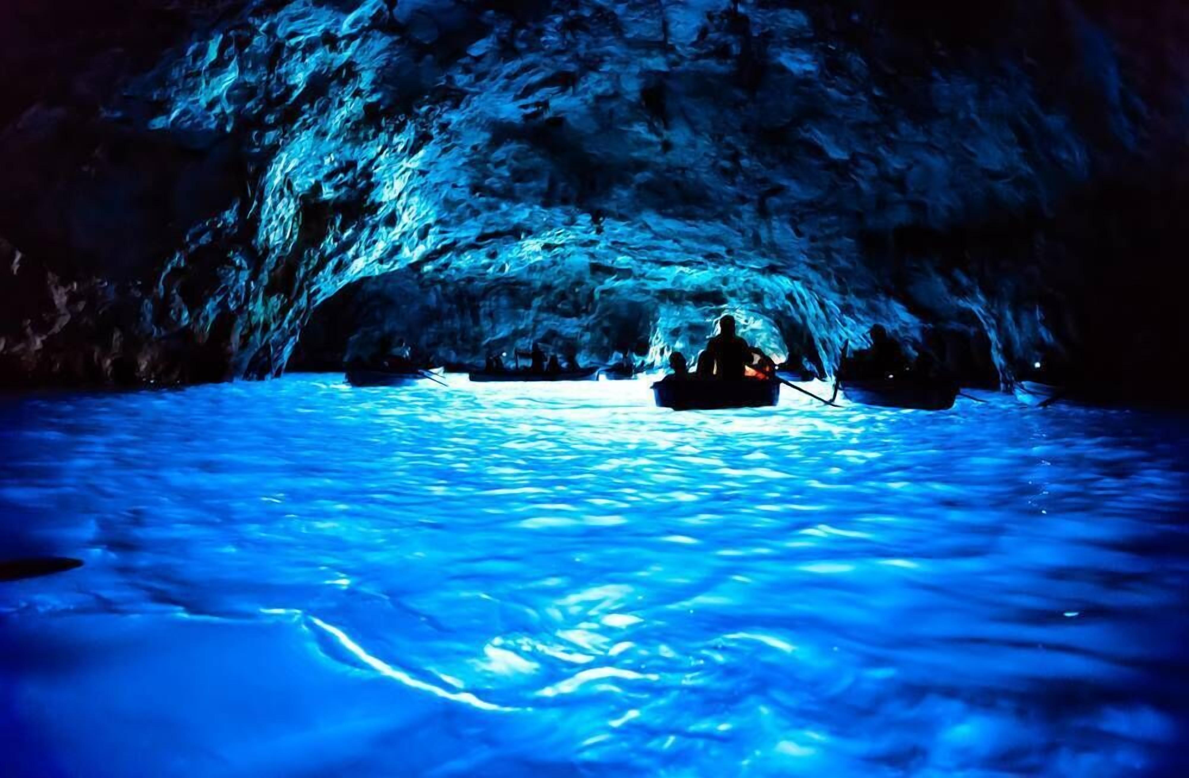 Une grotte dans laquelle se trouve un bateau sur l’eau.