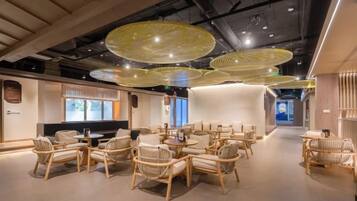 A modern interior with wicker furniture, pendant lighting, and a clean, minimalist design.