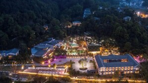 An aerial view of a resort with multiple buildings, a central courtyard, and surrounding greenery.