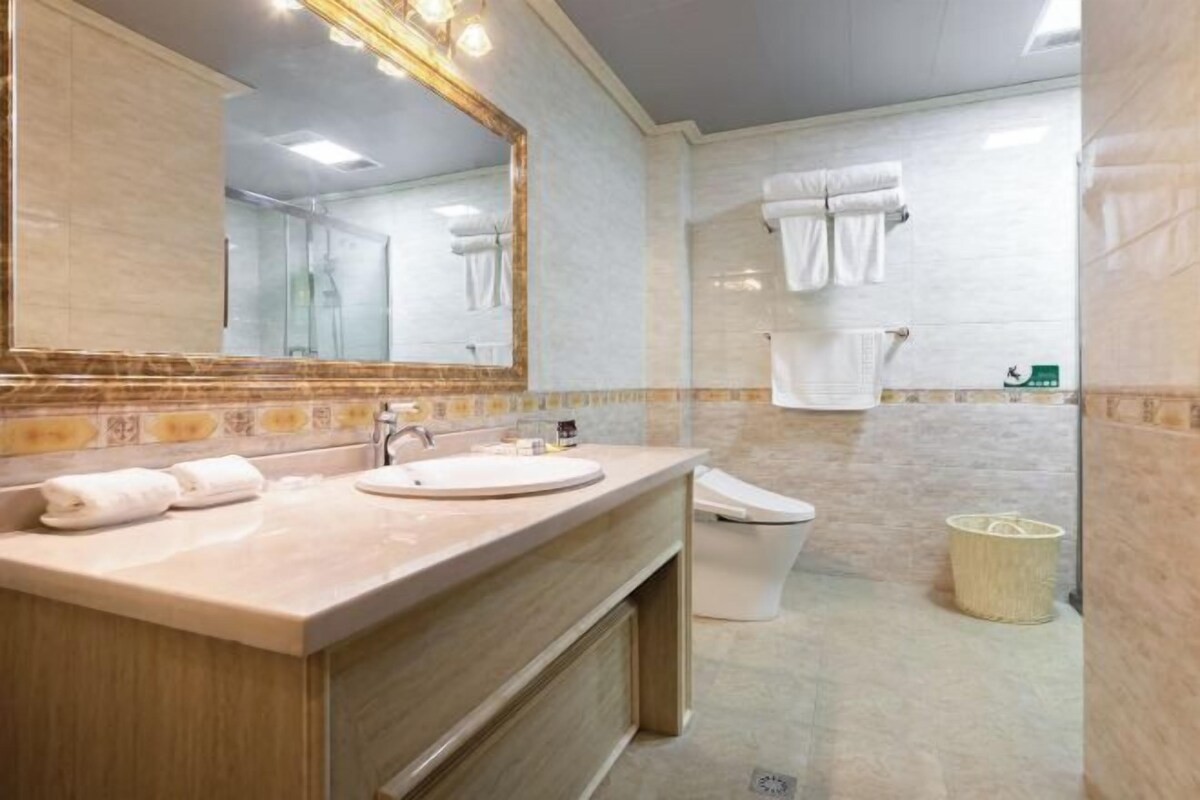 A bathroom with a sink, mirror, and toilet.