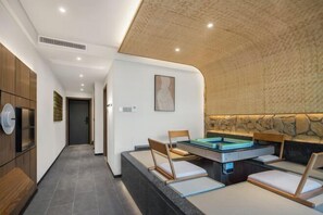 A modern room with a pool table, seating, and a stone accent wall. - Chongqing White-collars East Hotspring Hotel (Chongqing)