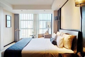 Una camera d'albergo con un letto grande, una scrivania e una sedia.