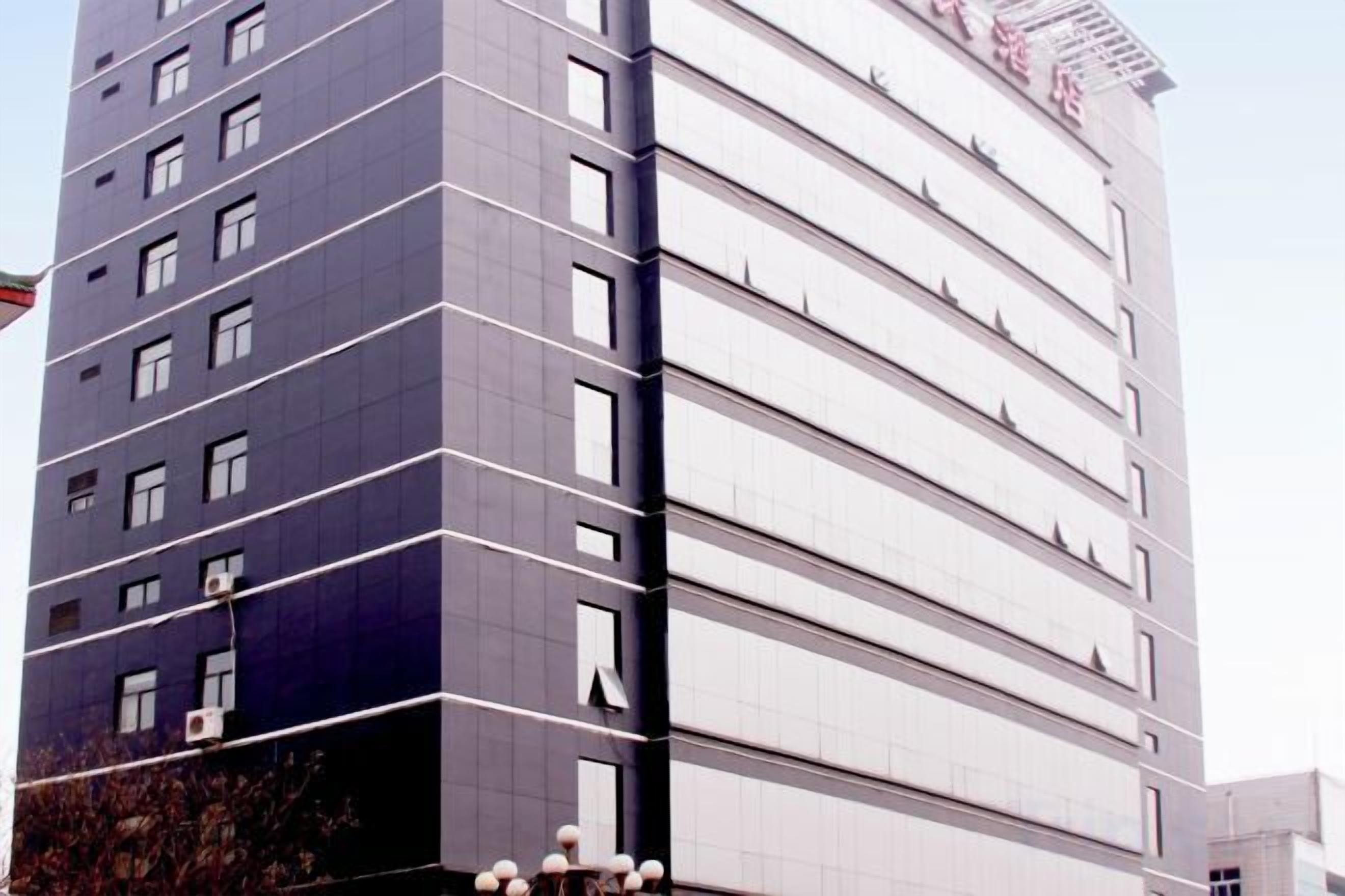 A multi-story building with a modern design, featuring a series of balconies and windows.
