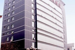 Un edificio moderno de varios pisos con una serie de balcones y ventanas.