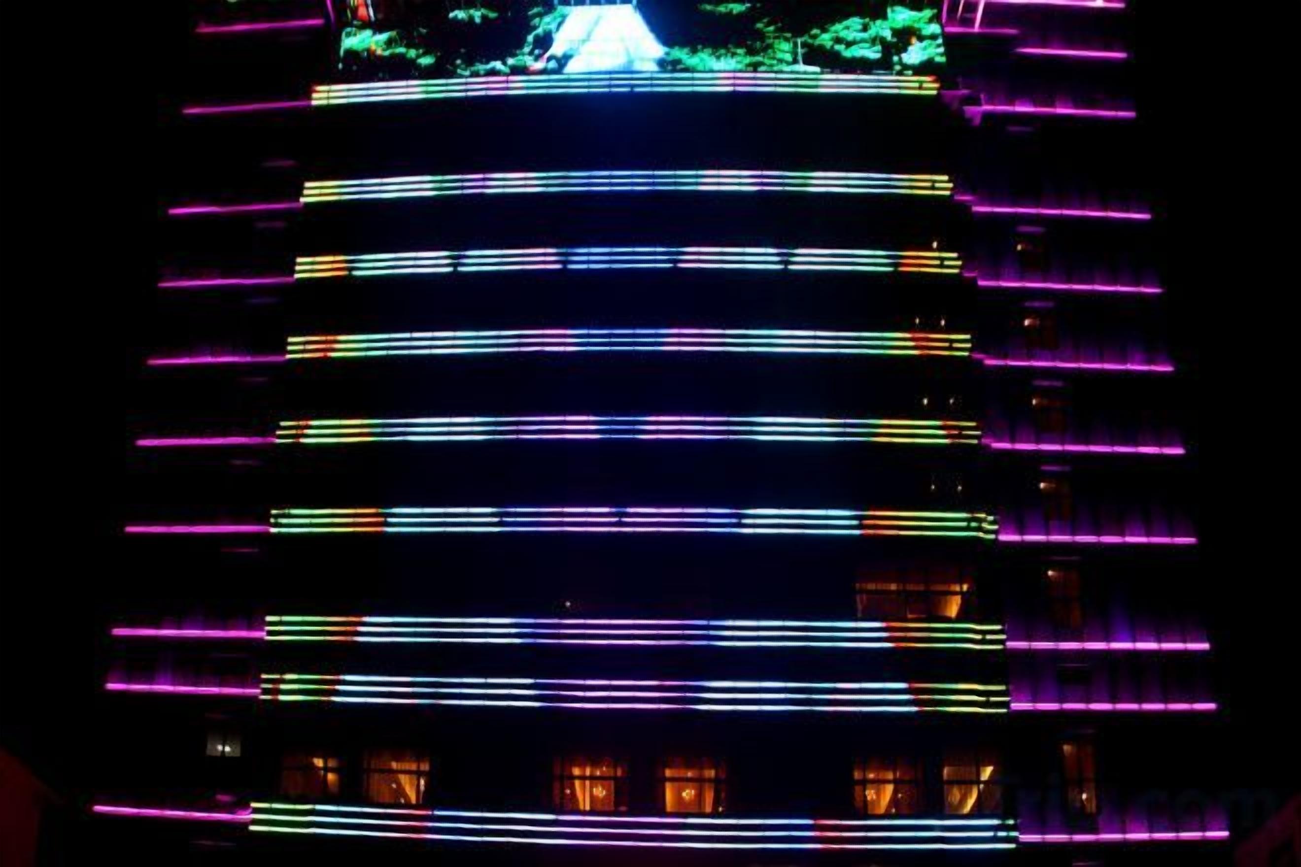 A multi-story building with horizontal lines of lights.