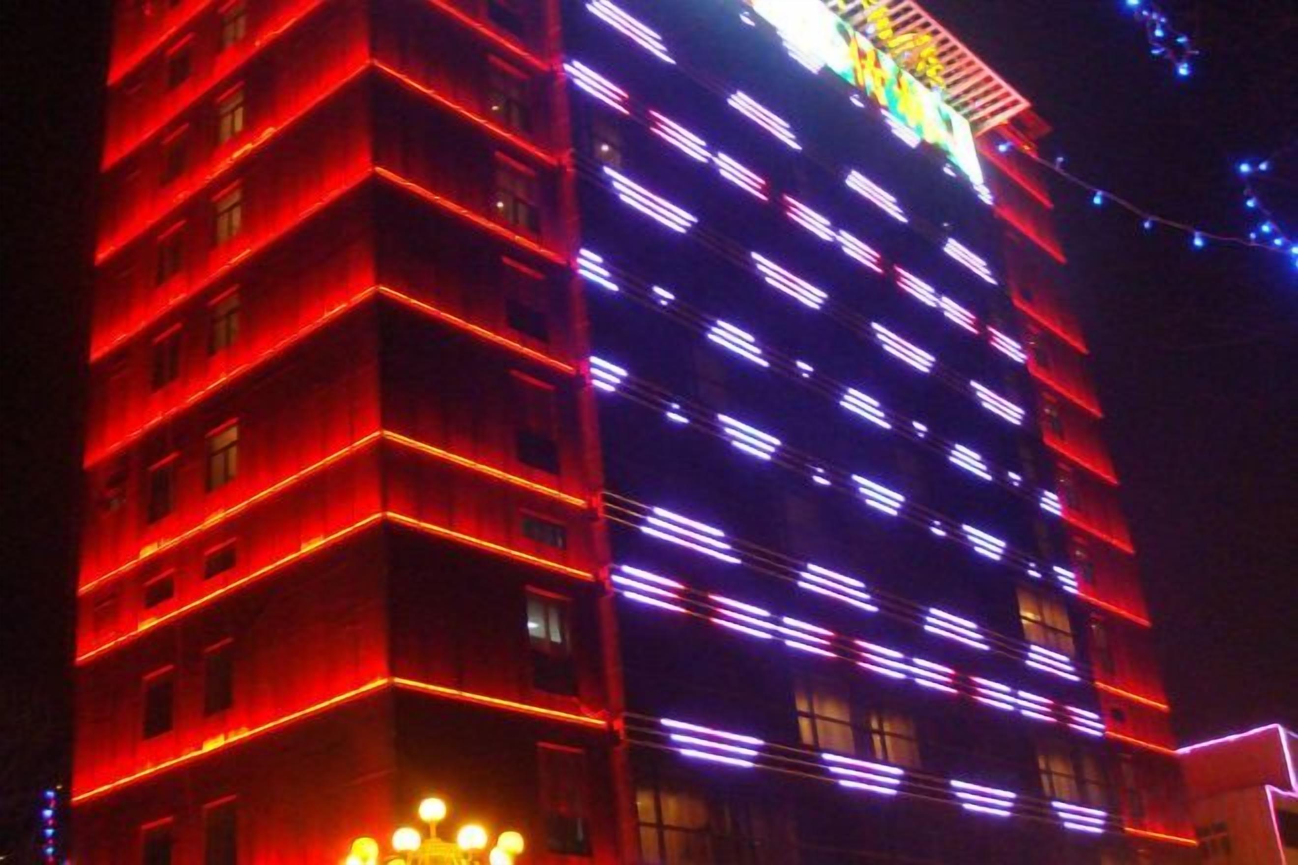 A multi-story building with illuminated windows and a prominent entrance.