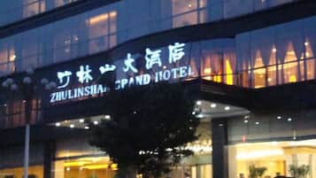 Un hotel con un cartel que dice "ZHULINSHA GRAND HOTEL" tanto en inglés como en chino.