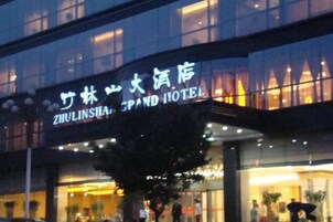 Un hotel con un cartel que dice "ZHULINSHA GRAND HOTEL" tanto en inglés como en chino.