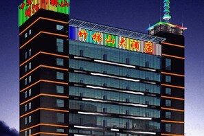 A multi-story building with a modern glass facade and illuminated signage.