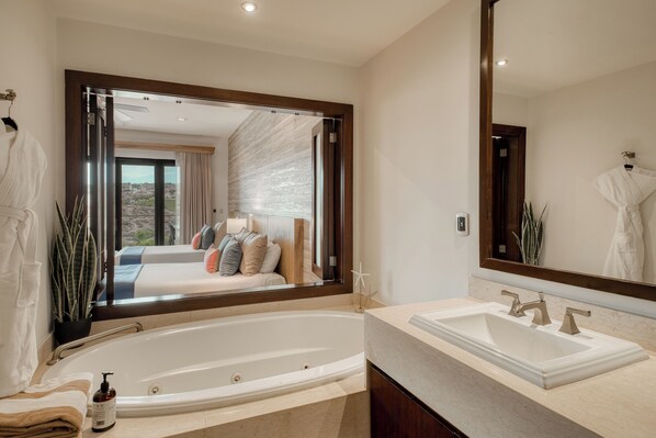 Un baño moderno con una bañera grande, un lavabo y un espejo.