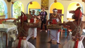A room with a central table, chairs, and a person in traditional attire. - Ravana Beach Cabanas (Dodanduwa)