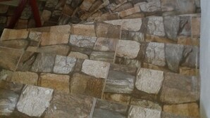 Una escalera con escalones de piedra y barandilla de metal rojo.