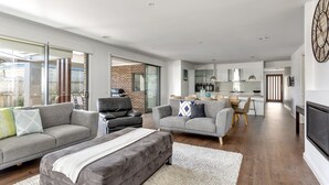 En moderne stue med grå sofaer, et hvidt tæppe og en pejs.