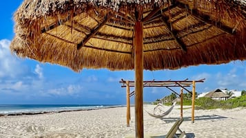Una playa cerca, sillas reclinables de playa, toallas de playa