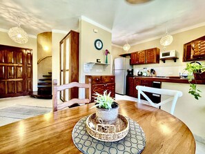 A kitchen with wooden cabinets, a microwave, and a clock on the wall.