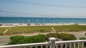 A beach view with a Durkin Realty sign, a road, and some greenery.