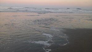 A beach with waves gently lapping at the shore. - Country house/farm in Peruíbe with adult and children's swimming pool, sauna and hot tub. (Estância Antonio Novaes)
