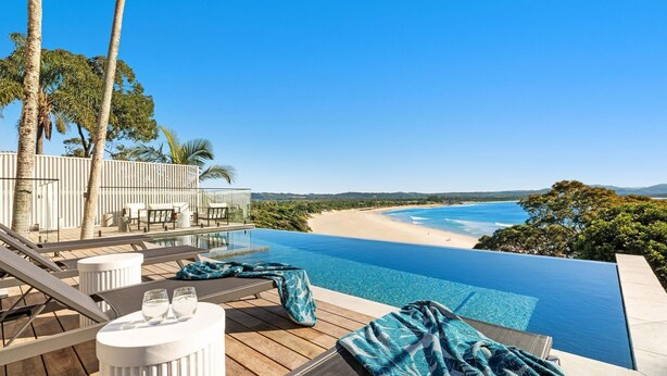 Ein Infinity-Pool mit Blick auf einen Strand und den Ozean.