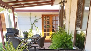 A covered outdoor seating area with a sofa, a table, and a potted plant. - ME MATES PLACE CLOSE TO THE BEST BEACHES THROUGH OUT THE ESPERANCE REGION,. (Condingup, ESPERANCE)