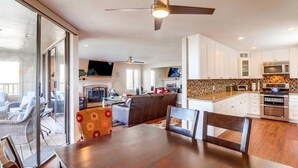 A modern kitchen with white cabinets, a large island, and stainless steel appliances. - Ocean View Condo Pool Spa Gym Tennis  (Del Mar)
