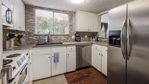 A modern kitchen with white cabinets, stainless steel appliances, a built-in oven, and a large refrigerator. - 5 bedrooms. 2 Blocks to Barton Springs Pool, Zilker Park, Music, Food Trailers (Austin)